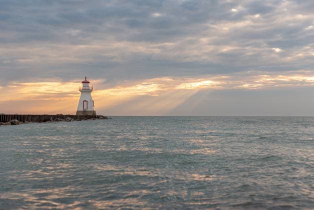 Beautiful lighthouse sits at end of pier with moody sunset sky Canada, Ontario, Southampton R_PKZL250405A-1699088-01