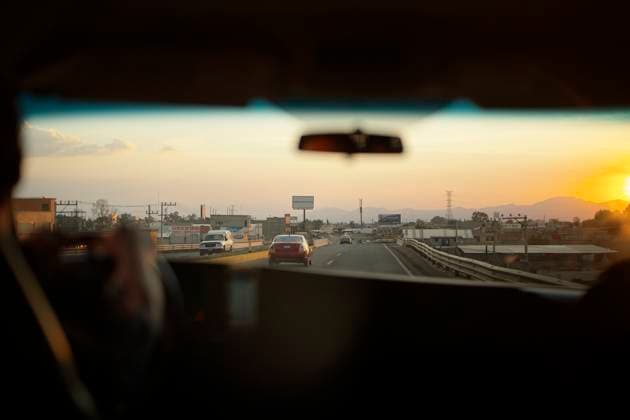 View from car interior driving on highway at sunset with clear skies and distant mountains. Mexico City, Mexico Mexico bola07909 Copyright: xConnectxImagesx