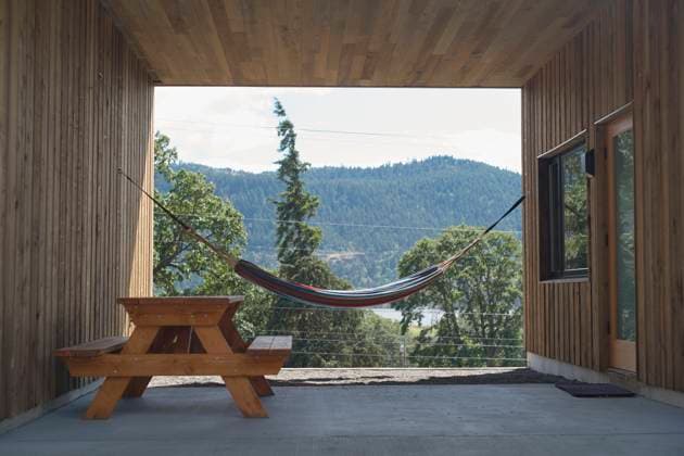Wooden patio with hammock and picnic table overlooking forested hills. Oregon, USA Oregon USA bola07948 Copyright: xConnectxImagesx