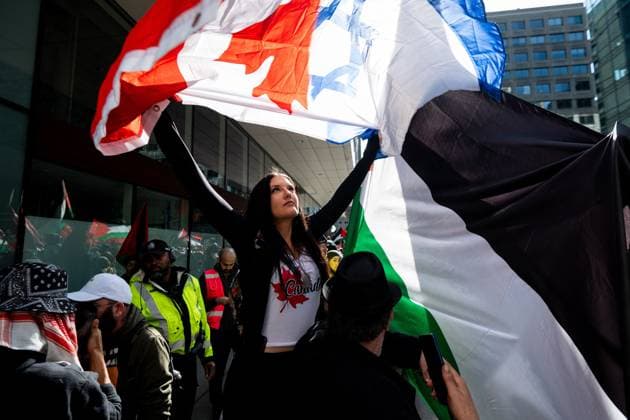 April 12, 2025, Ottawa, On, Canada: A Pro-Israel protestor waves a Canada and Israel flag in-front of Pro-Palestinian protestors during a demonstration protesters are calling a National March for Palestine in Ottawa, on Saturday, April 12, 2025. Ottawa Canada  - ZUMAc35_ 20250412_zaf_c35_059 Copyright: xSpencerxColbyx