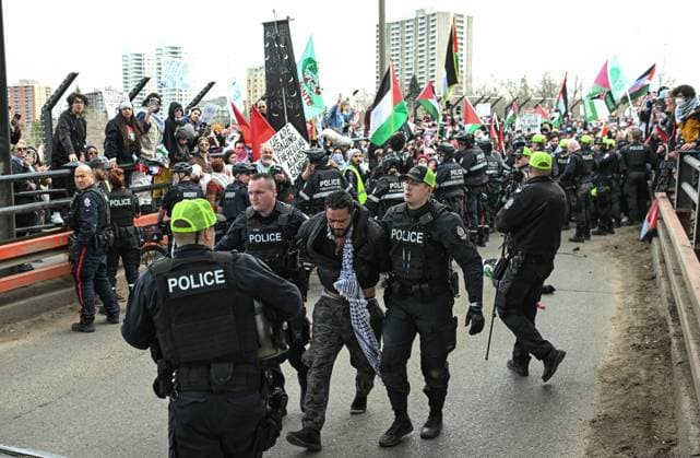 Demonstrators And Police Clash During Palestinian Solidarity Rally In Edmonton EDMONTON, CANADA APRIL 13 An activist is arrested as Edmonton Police attempt to push protesters off the vehicle lanes of the High Level Bridge and clear the way for traffic during the Stop the Genocide rally in Edmonton, Alberta, Canada, on April 13, 2025. The demonstration was held in solidarity with Palestinians amid growing demands for a ceasefire and international efforts to address the humanitarian crisis. Edmonton Canada  Copyright: xArturxWidakx originalFilename: widak-demonstr250413_npdFf.jpg