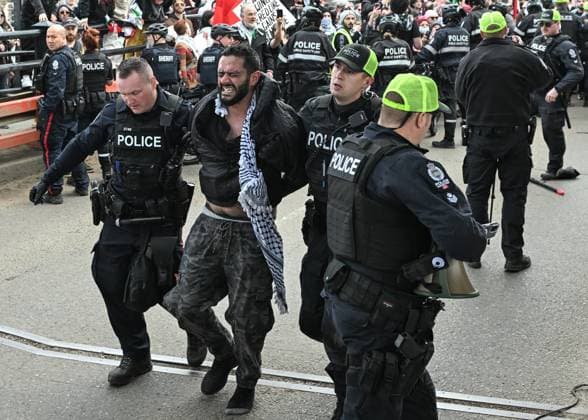Demonstrators And Police Clash During Palestinian Solidarity Rally In Edmonton EDMONTON, CANADA APRIL 13 An activist is arrested as Edmonton Police attempt to push protesters off the vehicle lanes of the High Level Bridge and clear the way for traffic during the Stop the Genocide rally in Edmonton, Alberta, Canada, on April 13, 2025. The demonstration was held in solidarity with Palestinians amid growing demands for a ceasefire and international efforts to address the humanitarian crisis. Edmonton Canada  Copyright: xArturxWidakx originalFilename: widak-demonstr250413_npbnc.jpg
