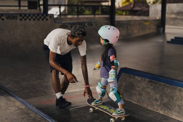 Creative Highlights Symbolfotos Girl skateboards down a ramp at a skate park with an instructor Kuta Utara, Bali, Indonesia CR_YUKI250412A-1673511-01 EDITORIAL USE ONLY