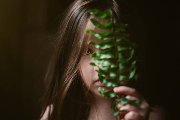 Creative Highlights Symbolfotos Girl holding fern leaf in front of face Tulsa, Oklahoma, United States CR_KRRY250412-1661736-01 ,model released, Symbolfoto