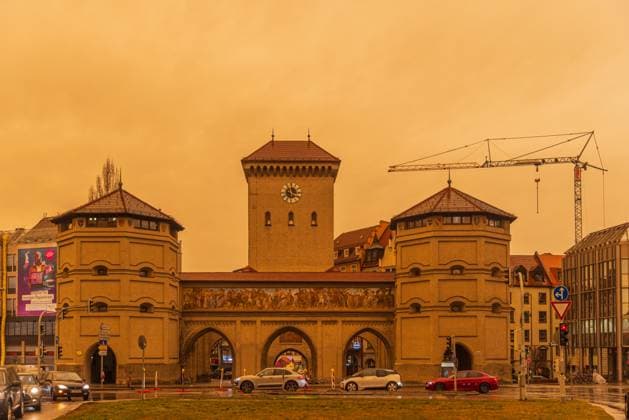 MUNICH, GERMANY - MARCH 16, 2022: Munich City Gate Isartor with dramatic orange sky produced by sand from the Sahara. Isartor gate in Munich with dramatic orange sky produced by sand from the Sahara. Munich Germany *** MÜNCHEN, DEUTSCHLAND 16. MÄRZ 2022 Münchner Stadttor Isartor mit dramatischem orangefarbenem Himmel, erzeugt durch Sand aus der Sahara Isartor in München mit dramatischem orangefarbenem Himmel, erzeugt durch Sand aus der Sahara München Deutschland Copyright: xx