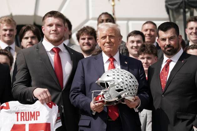 President Trump holds a helmet gifted to him by the 2025 College Football National Champions - The Ohio State University on the South Lawn of the White House in Washington, DC on Monday, April 14, 2025.  WAS20250414575 KenxCedeno