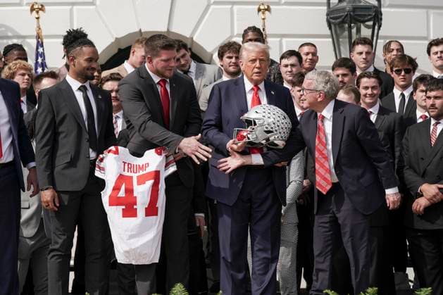 Ohio Governor Mike DeWine, right, shakes hands with a member of the 2025 College Football National Champions - The Ohio State University, as U.S. President Donald Trump looks on, on the South Lawn of the White House in Washington, DC on Monday, April 14, 2025.  WAS20250414589 KenxCedeno