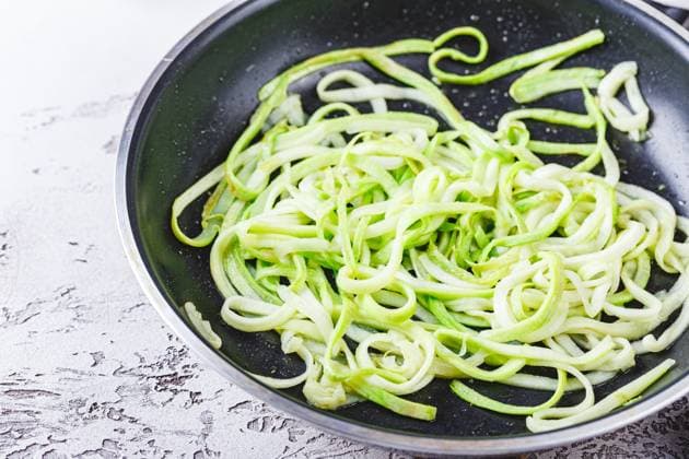 Zucchininudeln in Bratpfanne Zucchini noodles in frying pan on white background. Vegetarian dish. (License=RF) Copyright: xZoonar.com BurakovaxIrinax 23170690