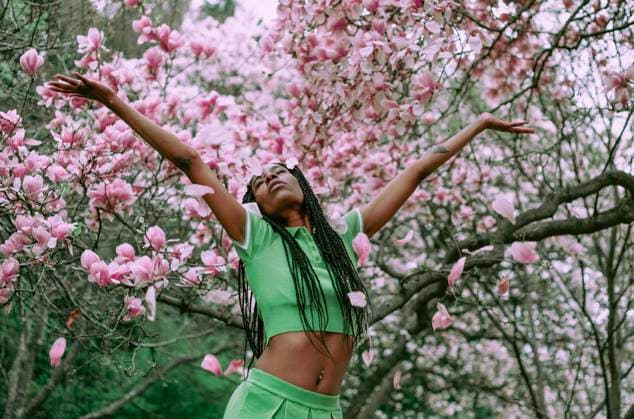 Creative Highlights Symbolfotos A beautiful black woman in a rain of magnolia petals Philadelphia, Pennsylvania, United States R_VDXM250415-1705063-01 ,model released, Symbolfoto
