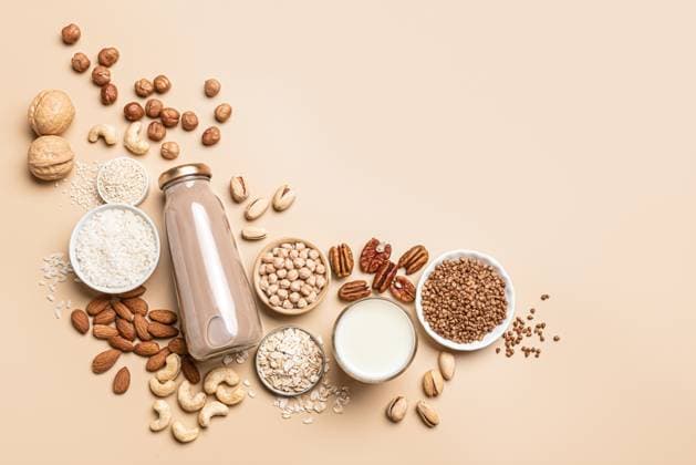 Vegane Milch und Zutaten auf Pflanzenbasis. Ersatzgetränk Vegan plant based milk bottles and ingredients, border. Non dairy, lactose free milk with nuts and grains on beige background, flat lay, copy space. Substitute drink, healthy fitness eating. (License=RF) Copyright: xZoonar.com OksanaxBratanovax 23166126