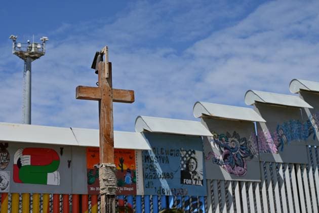 April 17, 2025, Tijuana, Baja California, Mexico: A wooden cross stands next to the border wall during the annual foot washing ceremony where volunteers wash and clean the feet of migrants during a ceremony for holy week in accordance to the twelve apostles remembrance of Jesus Christ Ã¢â‚¬oeFor I have given you an example, that you should do as I have done to youÃ¢â‚¬Â as Father Pat Murphy compares Jesus act to migrants plight and the unfair treatment of migrants and urged for a time of reflection for those seeking the right to freedom of movement and humanitarian asylum on Thursday, April 17, 2025 at TijuanaÃ¢â‚¬â ¢s Friendship Park circle on the US-Mexico border. Tijuana Mexico - ZUMAm180 20250417_zip_m180_007 Copyright: xCarlosxA.xMorenox