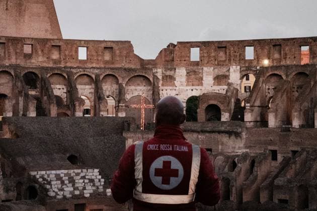 Rome, Via Crucis. Italian Red Cross volunteer observes the cross lit by flames inside the Colosseum.. On Good Friday before Easter, the Via Crucis retraces the stages of Christ s Passion. The celebration takes place in the heart of Rome, in front of the Colosseum, on April 18, 2025 in Rome, Italy. Copyright: xAndreaxCalandrax