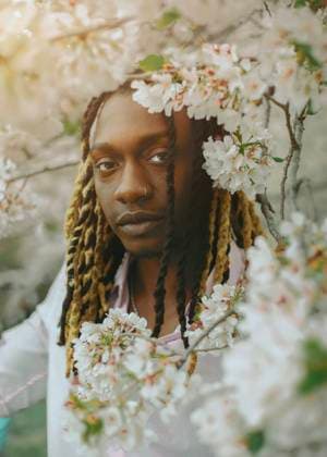 Creative Highlights Symbolfotos A black man with dreadlocks in a cherry blossom tree Philadelphia, Pennsylvania, United States CR_VDXM2504209A-1708883-01 ,model released, Symbolfoto