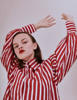 Creative Highlights Symbolfotos Fashion girl. Young brunette woman posing at studio in striped red and white shirt white skirt and trendy sandals. modern look. Belarus, Mogilev Region, Belarus R_PJWUOI210512C-745528-01 ,model released, Symbolfoto
