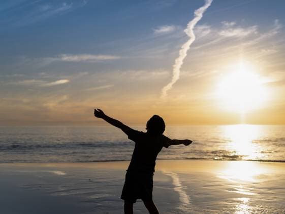Creative Highlights Symbolfotos Excited boy playing on the beach with sunset on horizon Adelaide, South Australia, Australia R_PAOL250422-1710182-01 ,model released, Symbolfoto