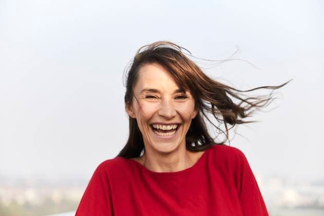 Creative Highlights Symbolfotos Mature woman laughing while standing against clear sky model released, Symbolfoto property released, FMKF06480