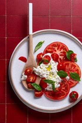 Top view of a beautifully composed caprese salad featuring sliced ripe tomatoes, creamy burrata cheese, and fresh basil leaves, delicately seasoned with olive oil and black pepper. Model Released JuliaKuvaldina_ID27903_801547_001 Copyright: xJuliaxKuvaldinax RECORD DATE NOT STATED