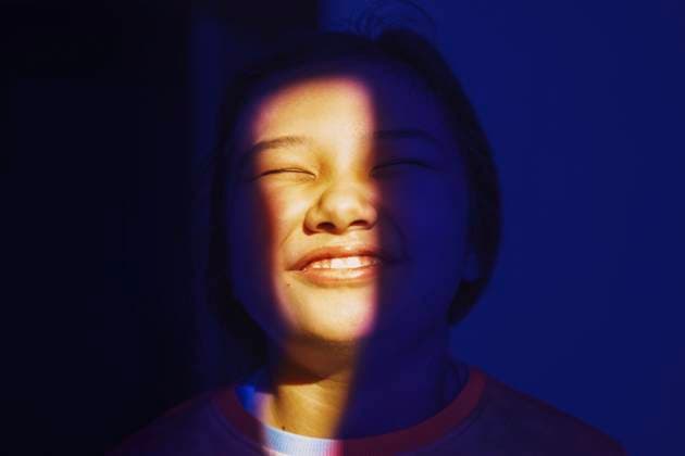 Creative Highlights Symbolfotos Cheerful girl with closed eyes in blue and yellow light model released, Symbolfoto, AZF00657