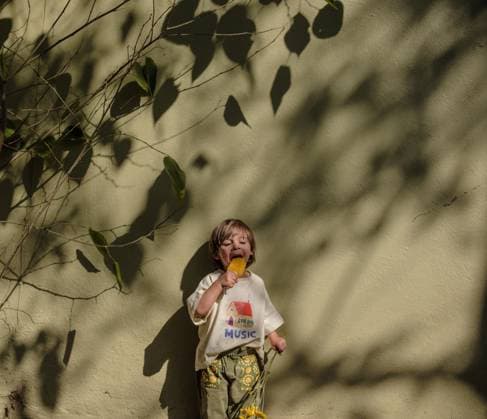 Creative Highlights Symbolfotos Boy Eating Popsicle Against Yellow Wall with Leaf Shadows San Miguel de Allende, Guanajuato, Mexico CR_WDJM250425-1718150-01 ,model released, Symbolfoto