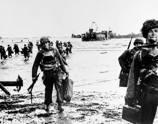 June 6, 1944, Colleville-Sur-Mer, Normandy, France: American assault troops, carrying full equipment, moving onto beachhead, landing craft jam harbor in background, Omaha Beach, Normandy, France, U.S. Army Signal Corps, June 6, 1944 Colleville-Sur-Mer France - ZUMAg145 19440606_aza_g145_007 Copyright: xJTxVintagex