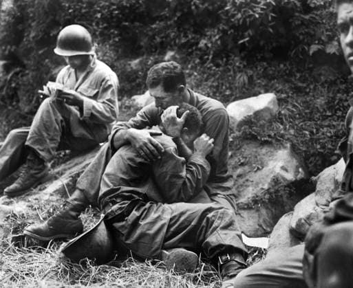 August 28, 1950, North Korea: Grief stricken American infantryman whose buddy had been killed in action being comforted by another soldier. In the background a corpsman methodically fills out casualty tags, Haktong-ni area, Korea, U.S. Army Signal Corps, August 28, 1950 North Korea - ZUMAg145 19500828_aza_g145_001 Copyright: xJTxVintagex