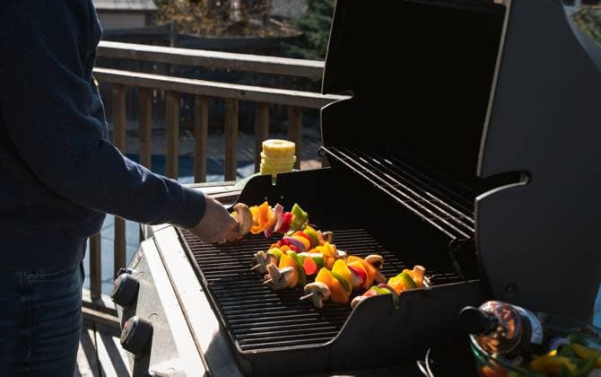 Man putting vegetable skewers on a gas bbq grill outdoors. Kingston, ON, Canada R_DOHO210506L-735069-01 ,model released, Symbolfoto