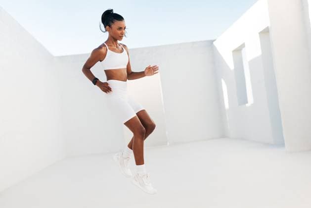 Creative Highlights Symbolfotos Eine schlanke Frau in weißer Sportkleidung springt in voller Länge im Freien. Professioneller Fitness-Sportler bei Aufwärmübungen. Full length of a slim female in white sportswear jumping outdoors. Professional fitness athlete doing warming up exercises. (License=RF) ,model released, Symbolfoto Copyright: xZoonar.com ArtemxVarnitsinx 23302963 ,model released, Symbolfoto ,property released