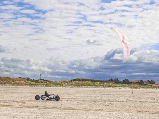 Freizeitsport Strandkiten am Rand des Nationalpark und UNESCO Weltnaturerbe, ausgewiesenes Kitegebiet, Kitebuggy mit beiden Füssen lenken, Fahrersitz mit Kiter zwischen Hinterachse und Vorderrad, hohe Geschwindigkeit, Westwinde, Dünen am Strand, Sonnenschein und blauer Himmel, Sankt Peter-Ording, Schleswig-Holstein, Deutschland, Europa Recreational sport Beach kiting on the edge of the national park and UNESCO World Heritage Site, designated kite area, kite buggy steered with both feet, driver s seat with kiter between rear axle and front wheel, high speed, westerly winds, dunes on the beach, sunshine and blue sky, Sankt Peter-Ording, Schleswig-Holstein, Germany, Europe Copyright: imageBROKER WolfgangxDiederich ibldie13400794.jpg