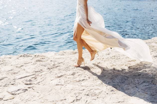 Creative Highlight Symbolbilder Die Beine der Braut in hochhackigen Sandalen und mit flatterndem Rock, die Braut geht am Pier entlang, Nahaufnahme Bride s legs in high-heeled sandals and with a fluttering skirt, the bride is walking along the pier, close-up . Copyright: imageBROKER NadtochiyxVladimir ibxiqx13172603.jpg ,model released, Symbolfoto ,property released
