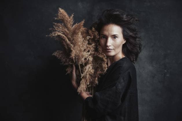 Schöne selbstbewusste Frau, die getrocknete Schilfpflanzen vor dem Hintergrund der Leinwand hält Beautiful confident woman holding dried reed plants against the canvas background Copyright: imageBROKER ArmanxZhenikeyev ibxazh13372820.jpg ,model released, Symbolfoto ,property released