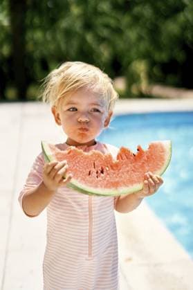 Creative Highlight Symbolbilder Ein kleines Mädchen ißt eine Wassermelone am Pool mit türkisfarbenem Wasser Little girl eats a watermelon near the pool with turquoise water. Copyright: imageBROKER NadtochiyxVladimir ibxiqx13180954.jpg ,model released, Symbolfoto ,property released