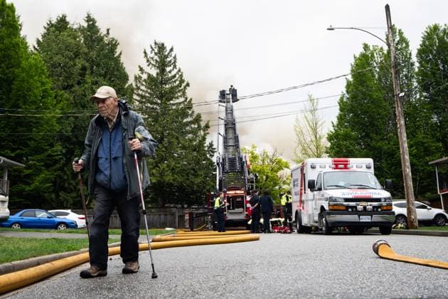 May 10, 2025, North Vancouver, Bc, CANADA: A man walks as the North Vancouver Fire Department fights a fire at Silverlynn Apartments, a three-storey seniors housing complex, in North Vancouver, B.C., Saturday, May 10, 2025. North Vancouver CANADA  - ZUMAc35_ 20250510_zaf_c35_037 Copyright: xEthanxCairnsx