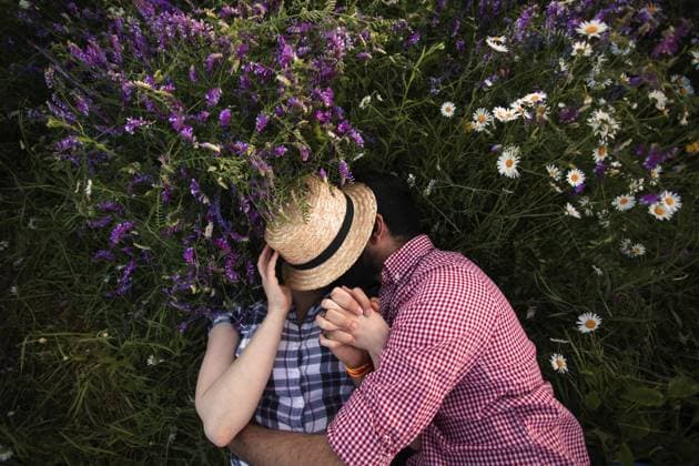 Creative Highlight Symbolbilder Romantisches Paar umarmt im Sommer Feld mit blühenden Wildblumen und küssen unter dem gewebten Hut Romantic couple embracing in summer field with blooming wildflowers and kissing under the woven hat Copyright: imageBROKER OksanaxShufrych ibxiqx13441222.jpg ,model released, Symbolfoto ,property released