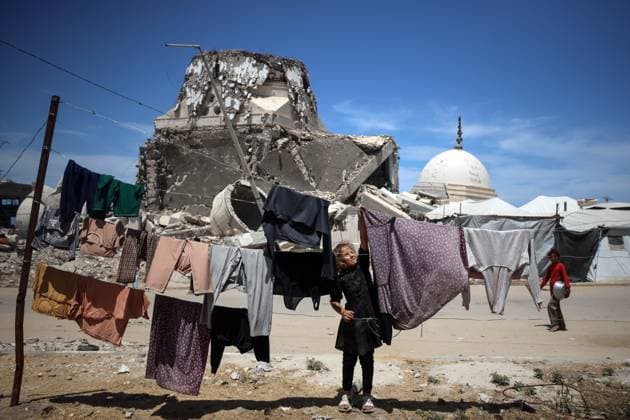 Bilder des Jahres 2025, News 05 Mai News Themen der Woche KW21 News Bilder des Tages Daily Life In Gaza A displaced Palestinian girl from the northern Gaza Strip, now in Gaza City, hangs laundry in front of Al-Hasayneh Mosque, which is severely damaged by Israeli airstrikes in western Gaza City, on May 20, 2025. Gaza s civil defense agency says Israeli strikes kill at least 44 people on May 20 across the war-ravaged Gaza Strip, where Israel intensifies a military offensive that they say aims at crushing Hamas. Gaza Palestine  Copyright: xMajdixFathix originalFilename: fathi-notitle250520_nptZ5.jpg