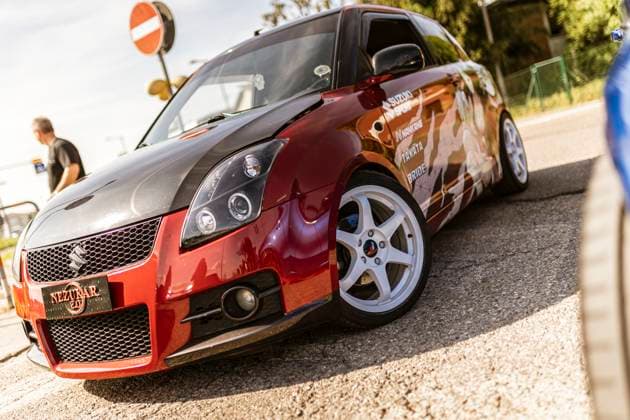 Rome, italy 4 may 2025: tuned red suzuki swift with carbon fiber hood, aftermarket rims and custom livery parked on asphalt Customized red suzuki swift showing tuning upgrades parked on asphalt Copyright: xfilippoxcarlotx _C5A4452
