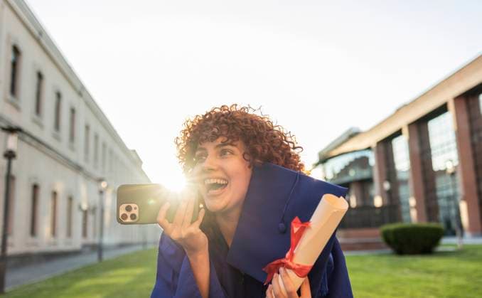 Creative Highlights Symbolbilder Young woman celebrating graduation on university campus holding diploma and phone model released, Symbolfoto, JCCMF13607