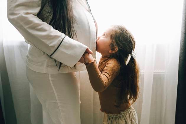 Creative Highlights Symbolbilder Little girl showing affection to her pregnant mother indoors model released, Symbolfoto property released, OLRF00414
