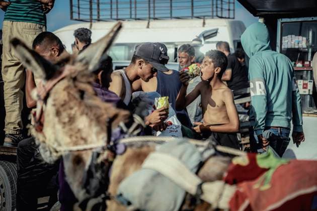 News Themen der Woche KW22 Bilder des Jahres 2025, News 05 Mai News Bilder des Tages Desperation Grows At Gaza Food Distribution A hungry young boy eats raw noodles as dislocated Palestinians carry the humanitarian aid they have received from a United Nations distribution point in Rafah, southern Gaza Strip on May 27, 2025, following a chaotic incident in which Gazans stormed the aid center, leading to the withdrawal of the American company overseeing the operation after losing control of the situation. The scene underscores the desperation and urgency surrounding the humanitarian crisis as aid systems struggle to meet the overwhelming needs of the population. Gaza Gaza Strip Palestinian Territories Copyright: xSaeedxJarasx