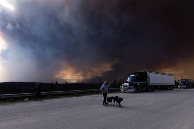 May 30, 2025, Buckinghorse River, Bc, Canada: Tourists take their dogs out for a quick break under billowing wildfire smoke off Highway 97 north of Buckinghorse River, B.C. on Friday, May 30, 2025. Buckinghorse River Canada  - ZUMAc35_ 20250530_zaf_c35_196 Copyright: xNasunaxStuart-Ulinx