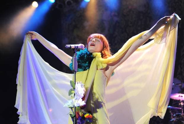 Florence and The Machine Live at The Greek Florence Welch of Florence & The Machine performs live at The Greek Theatre in Los Feliz, California, USA, June 13th 2011. music on stage concert gig performing half length yellow dress teal blue flower oversized corsage tattoo arm strapless cloak silk sheer bow tied high neck microphone singing mouth open arms outstretched flowers stand raised up CAP DVS DVS Los Feliz California United States Copyright: xDVS CapitalxPicturesx