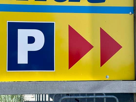 Gelb Blaues Hinweisschild Pfeile auf das Parken mit dem PKW Parklatz vor einem Supermarkt HH Deutschland *** Yellow Blue sign Arrows for parking with a car Parking lot in front of a supermarket HH Germany