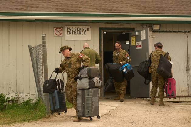 June 3, 2025, Norway House, Mb, CANADA: Royal Canadian Air Force Pte. Carter Brinn (left) and Maj. Mathew Strong (center) help cary evacuees baggage as board a C-130 Hercules aircraft in Norway House, Man., Tuesday, June 3, 2025, at the Norway House Airport as crews continue to fight wildfires in northern Manitoba. Norway House CANADA  - ZUMAc35_ 20250603_zaf_c35_057 Copyright: xDavidxLipnowskix