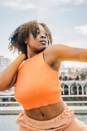 Creative Highlights Symbolbilder Close-up of woman in orange top posing with cityscape behind New York, New York, United States CR_FKNH2506029D-1705864-01 ,model released, Symbolfoto