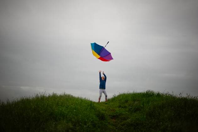 IMAGO Creative, Jahreszeit Sommer, Regen, Sommerregen Tween girl tossing colorful umbrella cloudy grey skies Ohio City, Ohio, United States CR_JOKU250606-1746366-01 ,model released, Symbolfoto