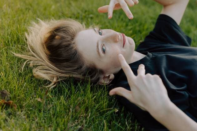 Creative Highlights Symbolfotos Teenager lying on grass making hand gestures Boise, Idaho, United States CR_PHZD250609A-1747602-01 ,model released, Symbolfoto