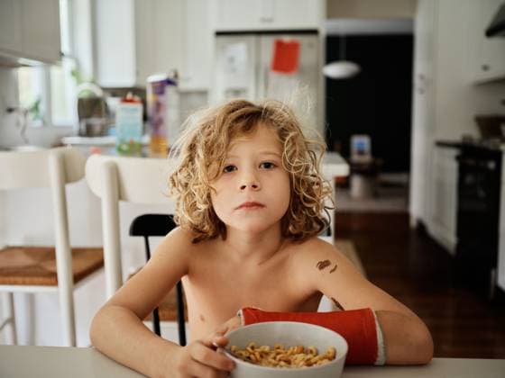 Creative Highlights Symbolfotos young boy eats breakfast with a broken arm Bedford, New York, United States CR_JOBADO250610-1763926-01 ,model released, Symbolfoto