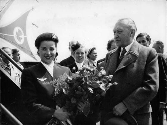 Frankreich Monaco Sark 5. Mai 1953 Adenauer reist nach Paris. Teilnahme an der Konferenz der Europäischen Kommission für Kohle und Stahl. Dr. Konrad Adenauer, Bundeskanzler der Bundesrepublik Deutschland, soll Deutschland verlassen, um an der Konferenz der Europäischen Kommission für Kohle und Stahl teilzunehmen. Bevor er an Bord ging, überreichte ihm die 22-jährige Air-France-Stewardess Margot Wirges aus Köln, Adenauers Geburtsstadt, einen großen Strauß Gloria-de-Rosen, des Kanzlers Lieblingsblumen. Das Foto zeigt Dr. Konrad Adenauer und Air-France-Stewardess Margot Wirges am 11. Mai 1953 auf dem Luftwaffenstützpunkt Köln-Wahn. *** France Monaco Sark 5 May 1953 Adenauer travels to Paris Participation to the Conferenc  Copyright: xUnitedxArchivesx xkpaxKeystonex 19530505_baf_k09_311