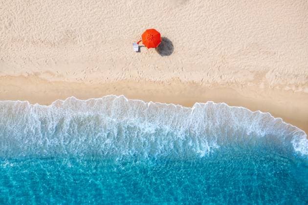 Creative Highlights Symbolfotos Aerial view of red umbrella on white empty sandy beach, blue sea with waves at sunset in summer. Resort in Sardinia, Italy. Tropical seaside with turquoise water. Travel and vacation. Top view Model Released DenisBilytskyi_ID29253_934967_014 Copyright: xx
