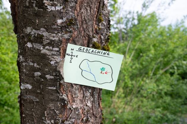 Geocaching, Freizeitbeschäftigung im Freien, Navigation zum Versteck, Geocache im Wald finden, Schatzsuche, Notiz am Baumstamm Geocaching, outdoor recreational activity, navigation to hide and seek containter, geocache location in forest, treasure hunting game, note on tree trunk (License=RF) Copyright: xZoonar.com BeritxKesslerx 23566240