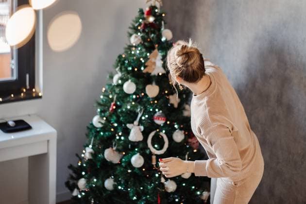 Woman in Cozy Christmas Setting Decorating a Christmas Tree Milan, Lombardy, Italy R_NEPM250511-1309275-01 ,model released, Symbolfoto
